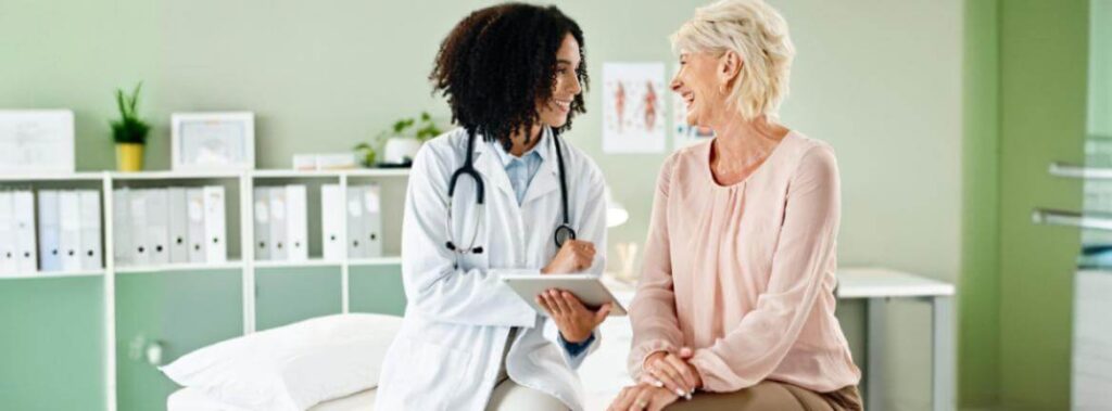 Profissional de saúde com um olhar acolhedor conversa com uma paciente, ilustrando a importância da indicação médica e do amparo durante o tratamento oncológico.