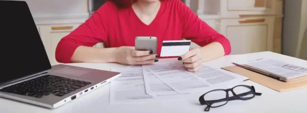 Consumidora analisa cobertura do seguro viagem oferecido pelo seu cartão de crédito.