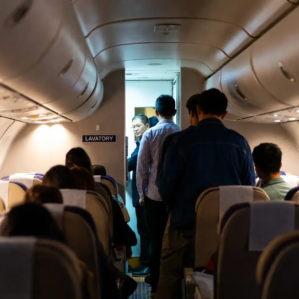 Filas e desconforto causados pela restrição de banheiro premium em aeronaves, afetando consumidores em voos lotados.