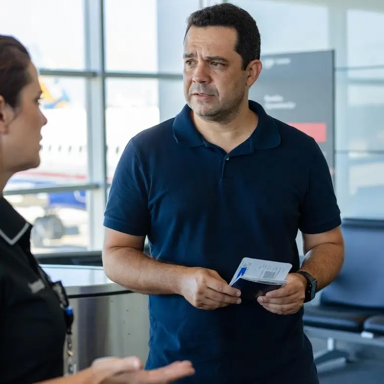 Passageiro brasileiro sendo impedido de embarcar no portão do aeroporto devido a overbooking da companhia aérea